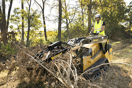 Mini skid steer cleaning up tree branches