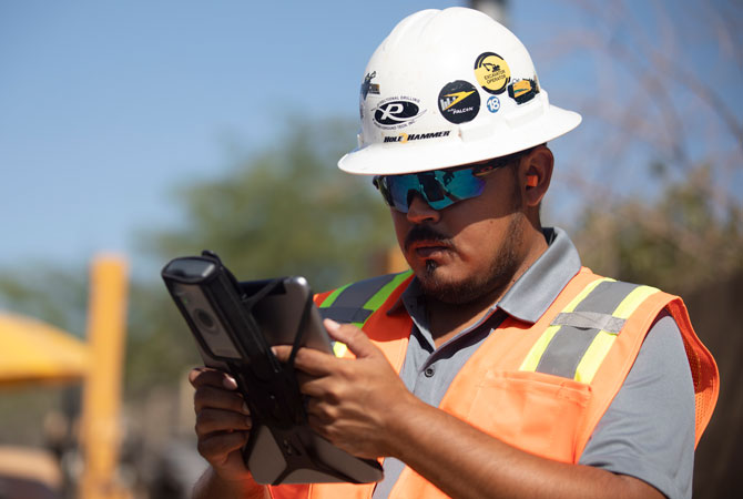 Jobsite worker using digital tools on a tablet