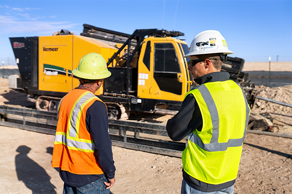 Dealer rep and drill owner looking at a drill in the field.